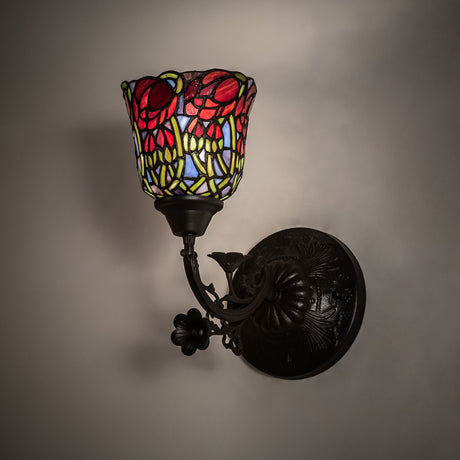 Red rosebud wall sconce illuminated, showcasing its vibrant stained-glass design.