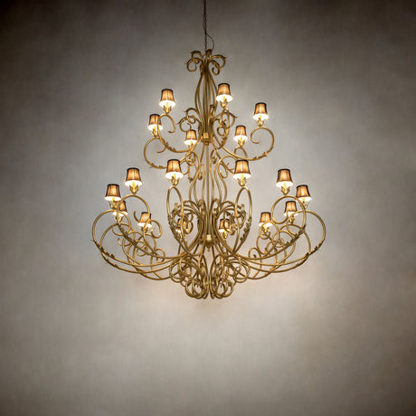 Spanish gold Alexandria chandelier illuminated in dark room setting.