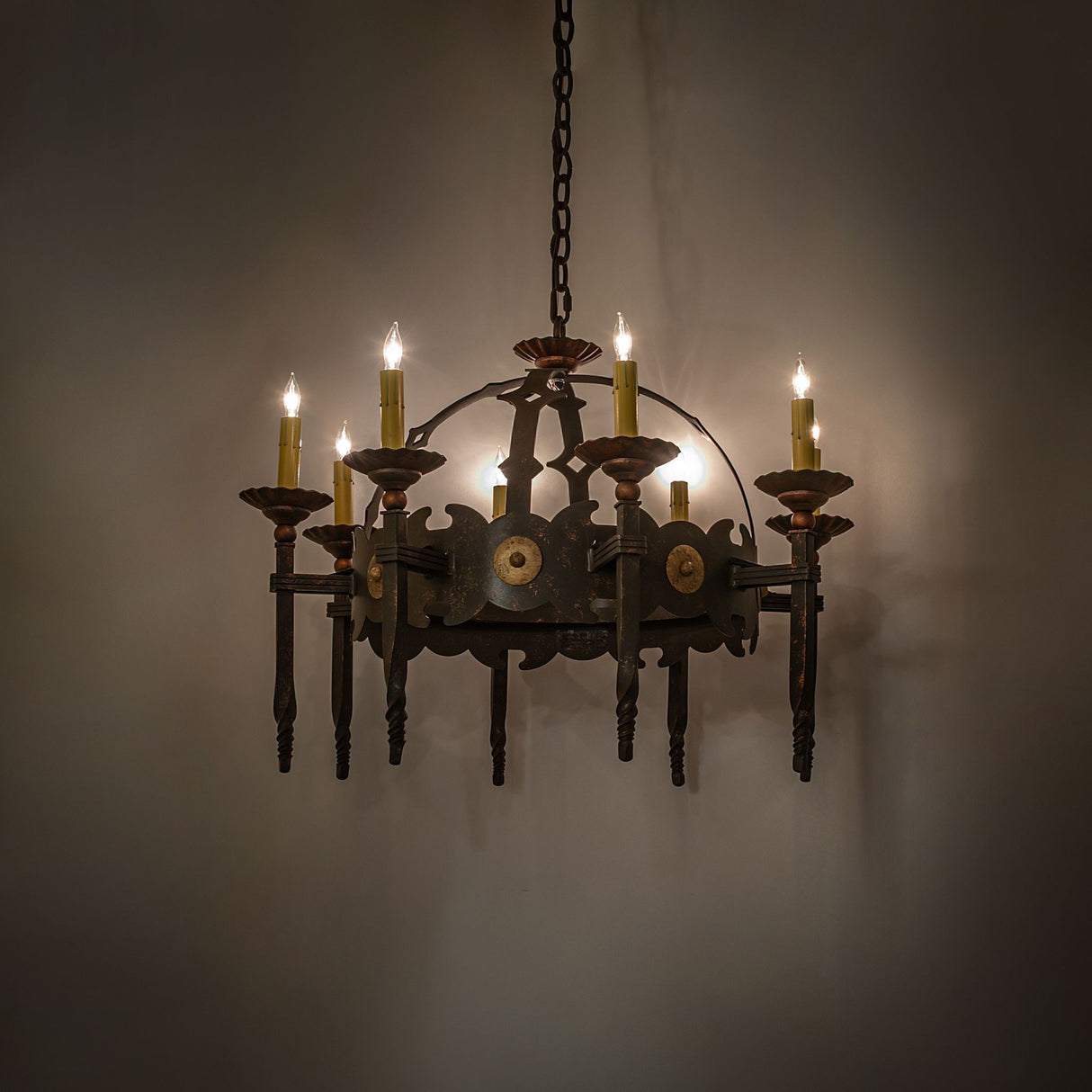 Gilded tobacco Antibes chandelier illuminated in interior setting.