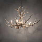 Elk antler chandelier softly illuminated in an ambient room.