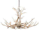 Lit view of Elk antler chandelier glowing with warm candle-style bulbs.