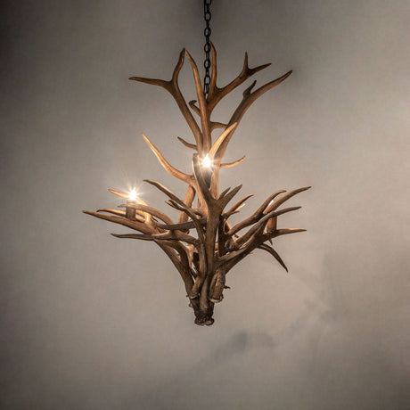 Ambient view of natural antler chandelier creating a cozy glow in rustic living spaces.