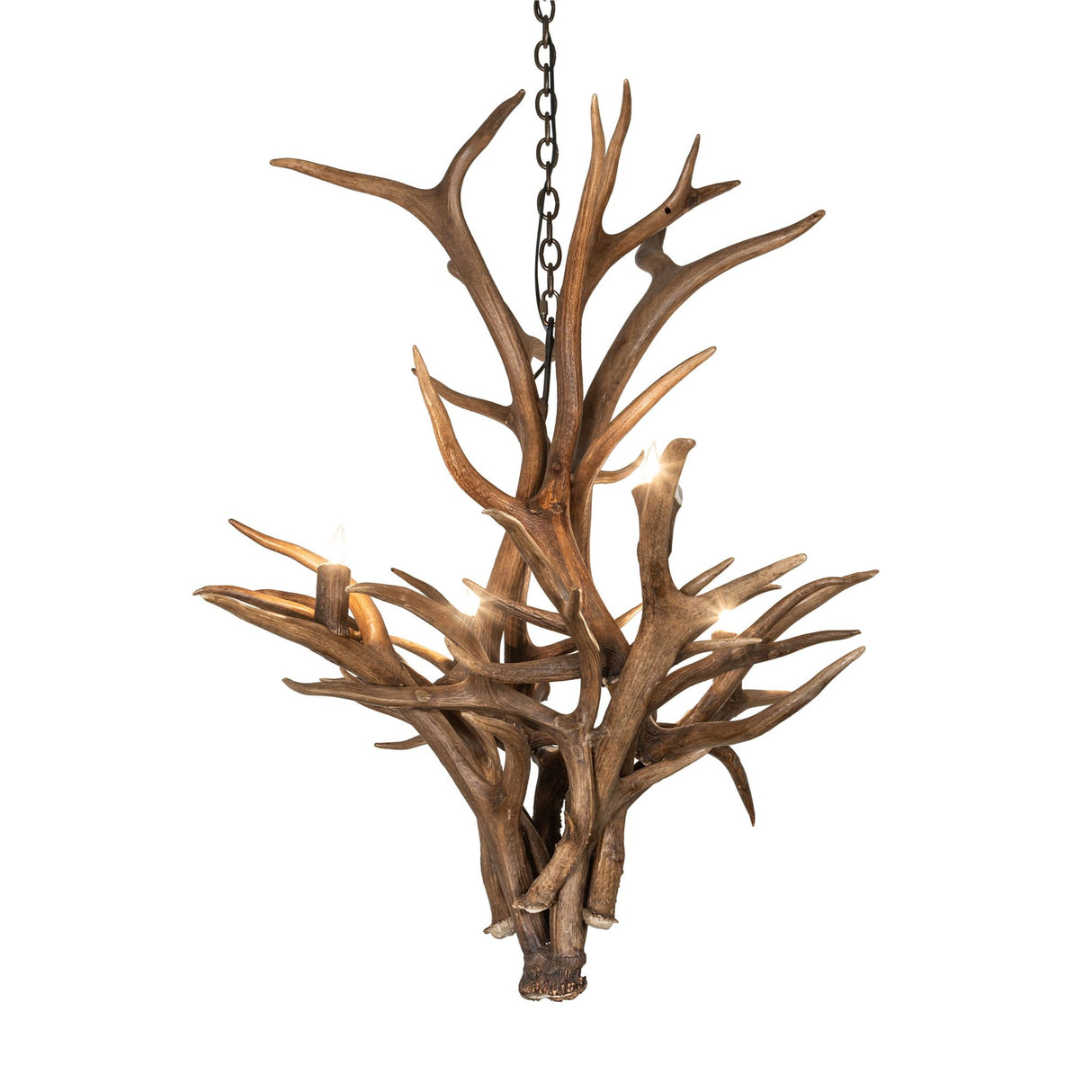 Lit view of deer antler chandelier casting warm rustic light in cabins and lodge-style interiors.