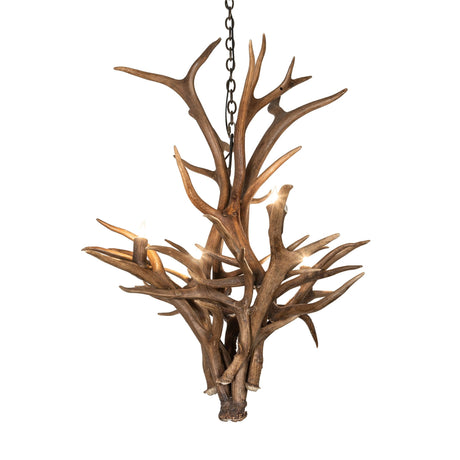 Lit view of deer antler chandelier casting warm rustic light in cabins and lodge-style interiors.