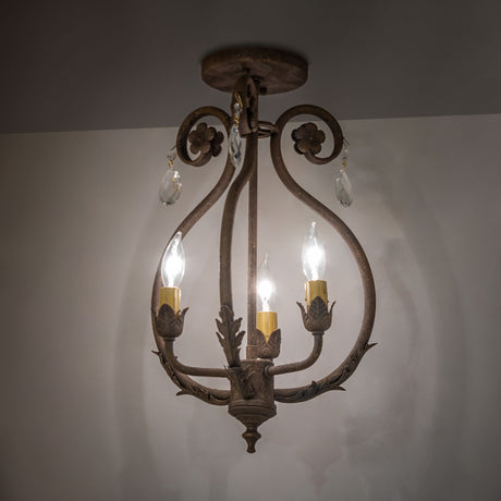 Ambient view of chandelier, highlighting crystal accents, floral details, and warm antiquity finish.