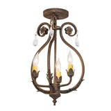 Lit view of chandelier with antiquity finish, scrolled arms, crystal drops, and ivory candle-style bulbs.