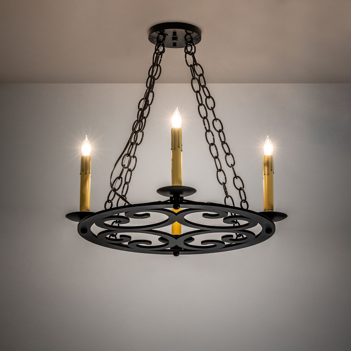 Ashley 4-light blackwash chandelier lit ambient room view.
