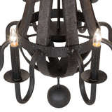 Close-up of faux candle bulb, bobeche, and hammered black metal arm with charred wood backdrop.