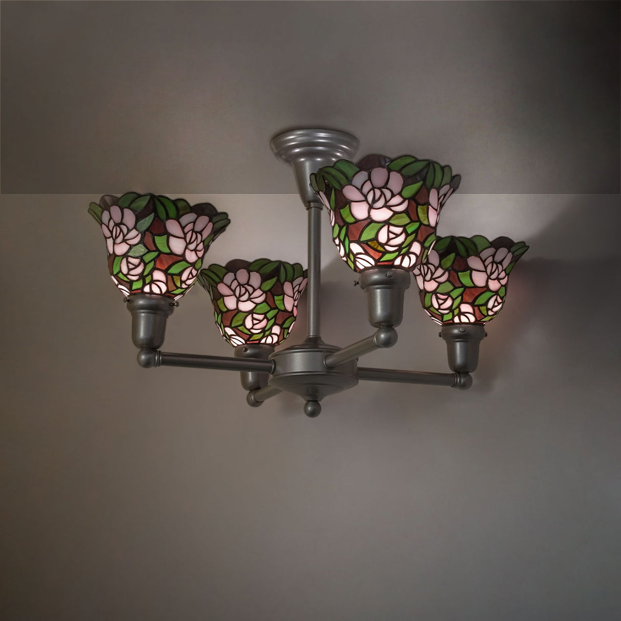 Begonia 4 light chandelier illuminated in room setting with floral stained glass shades.
