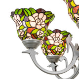 Close-up detail of stained glass shade featuring blush pink flowers and green leaf pattern.