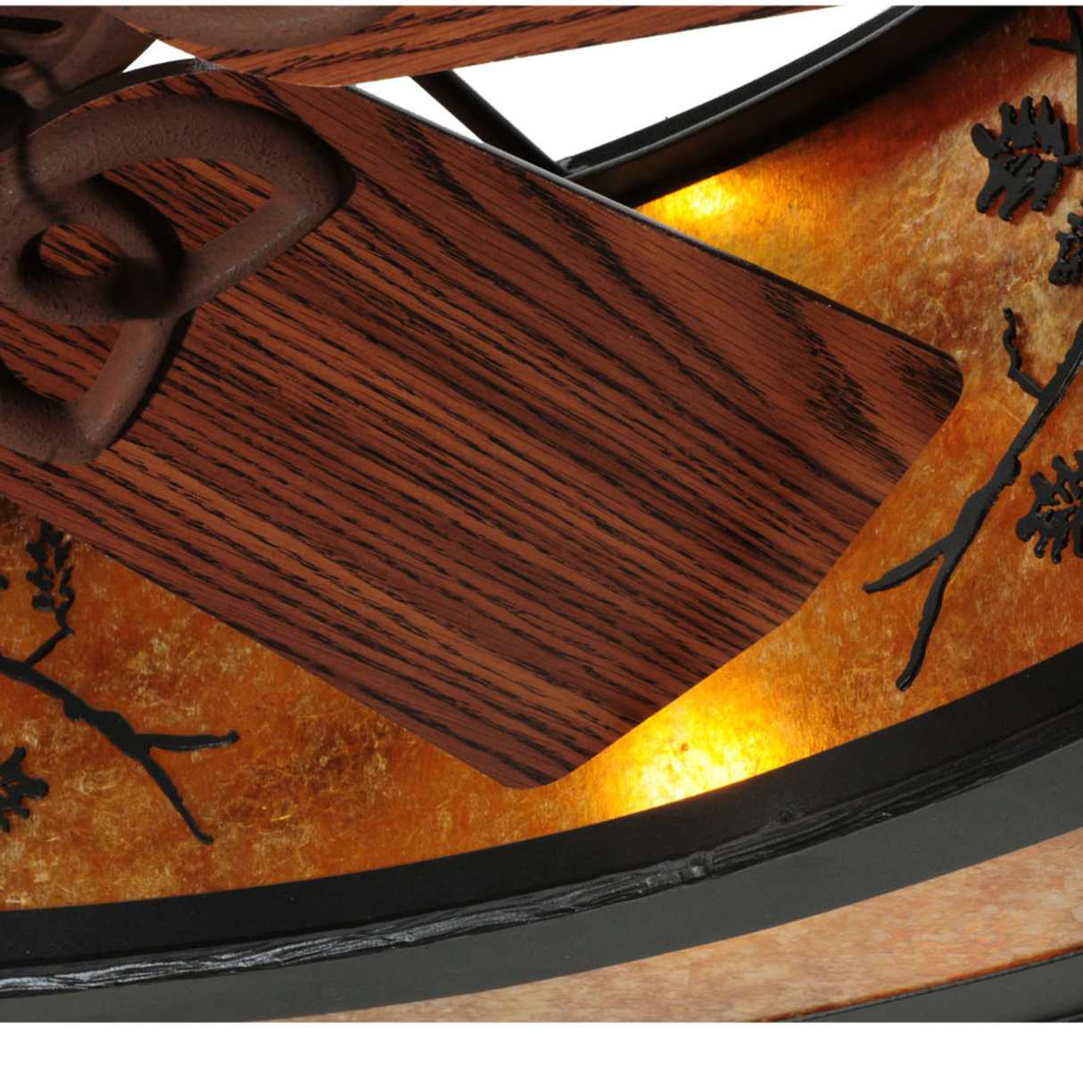 Close-up of fan blade and illuminated amber mica diffuser with branch design.