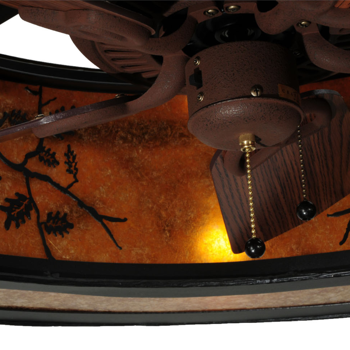 Detailed view of fan center and pull chains under warm amber lighting.