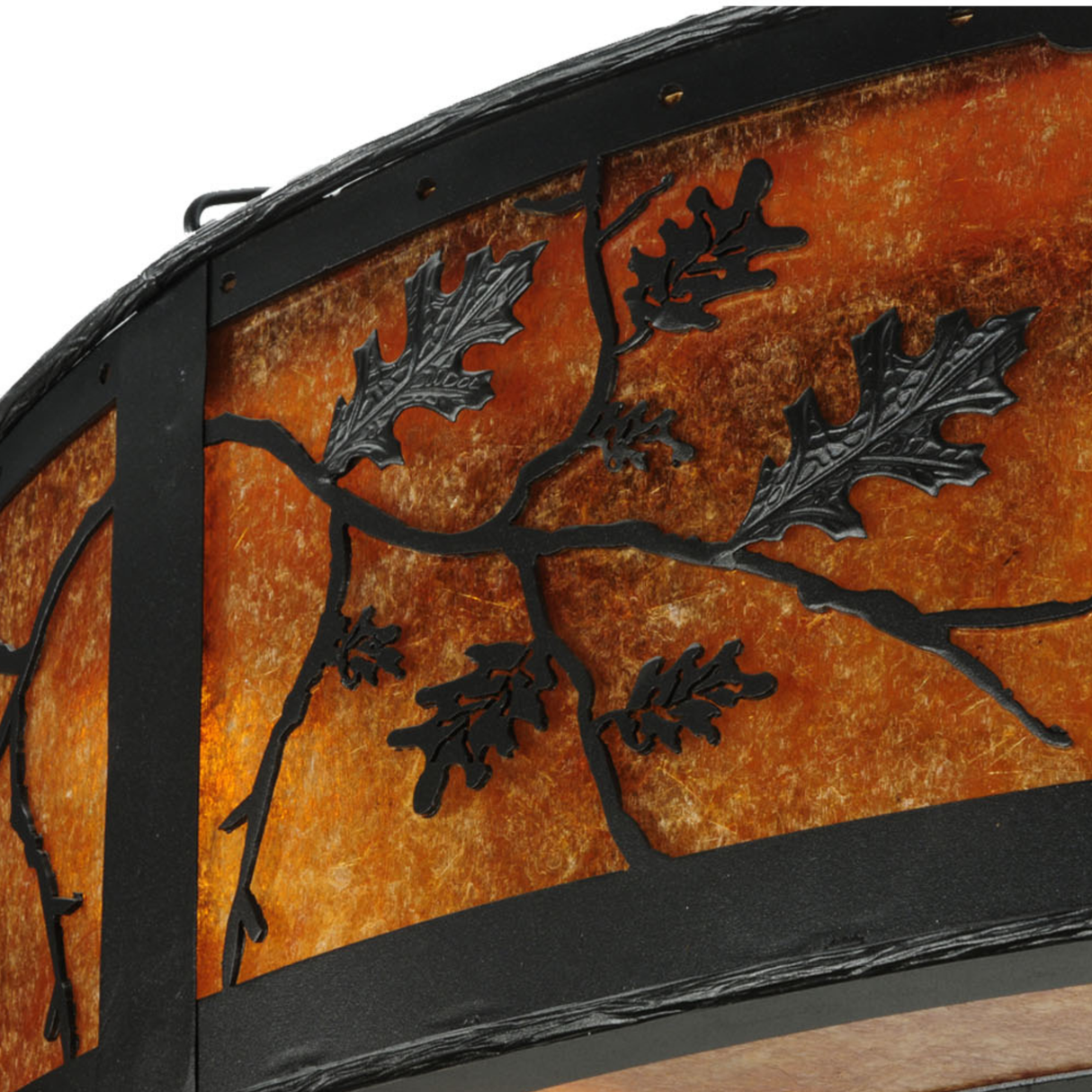 Close-up of oak leaf and branch metalwork on illuminated mica surface.