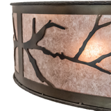 Close-up showing hand-forged branch silhouette on illuminated mica surface.