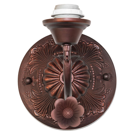 Close-up of intricate detailing on the bronze wall sconce.