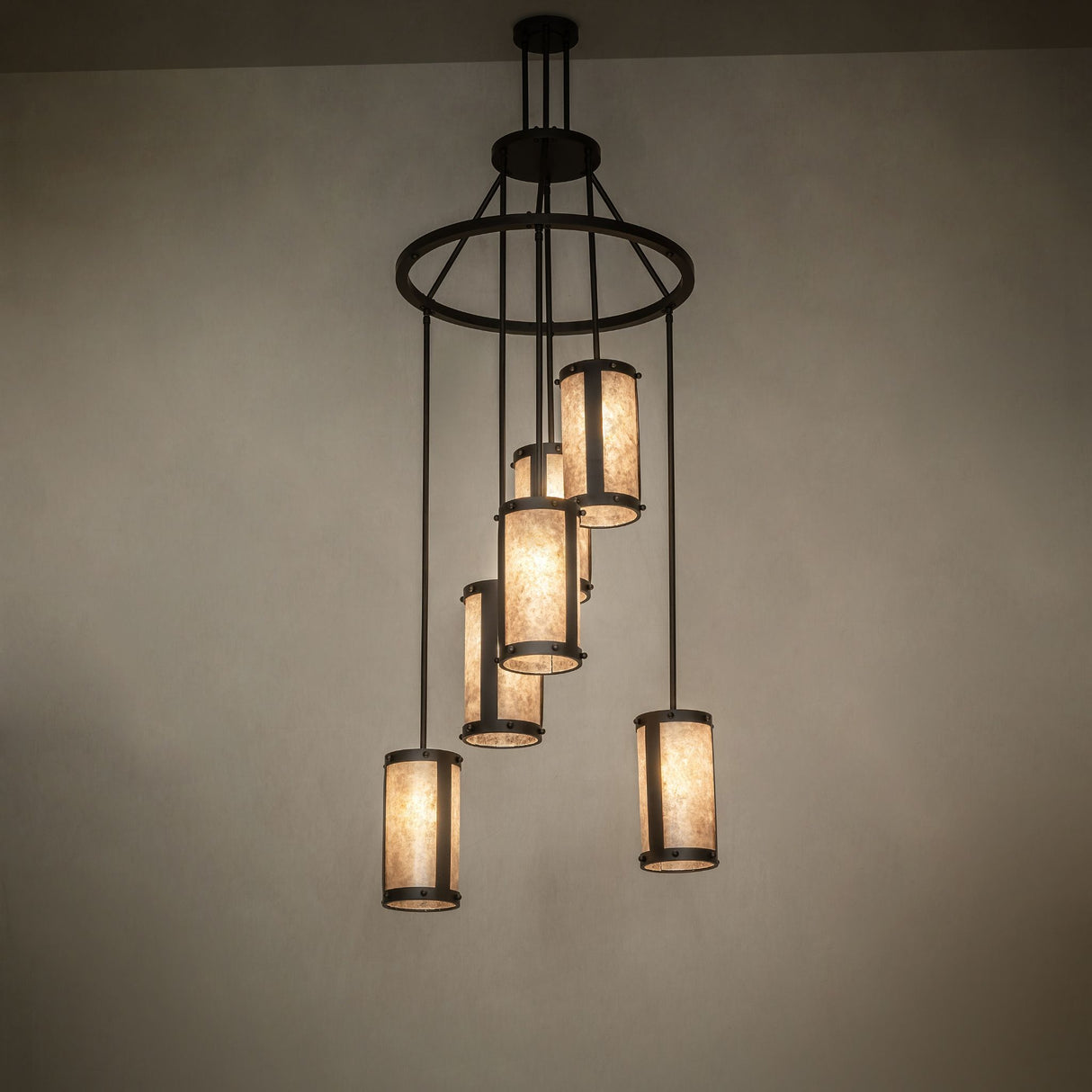 Ambient view of the Cartier 6-light cascading chandelier illuminating in a dark room.