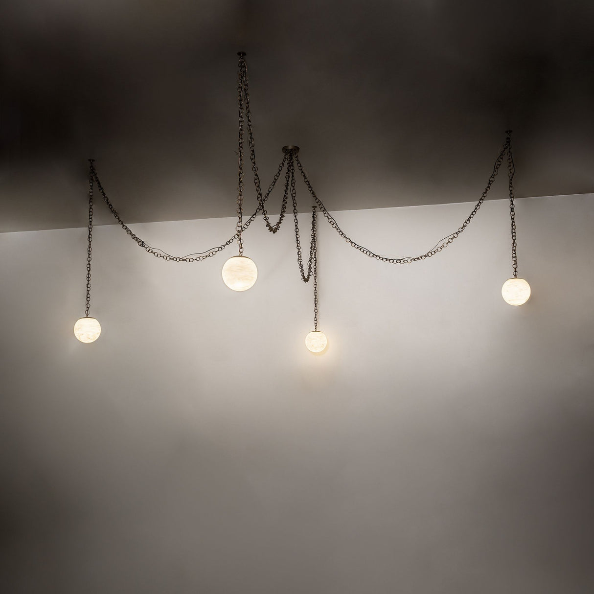 Ambient lighting view of Castiliolite Bola chandelier with softly glowing alabaster globes.