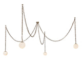 Lit view of 4 light chandelier with alabaster glass globes and brass chains.