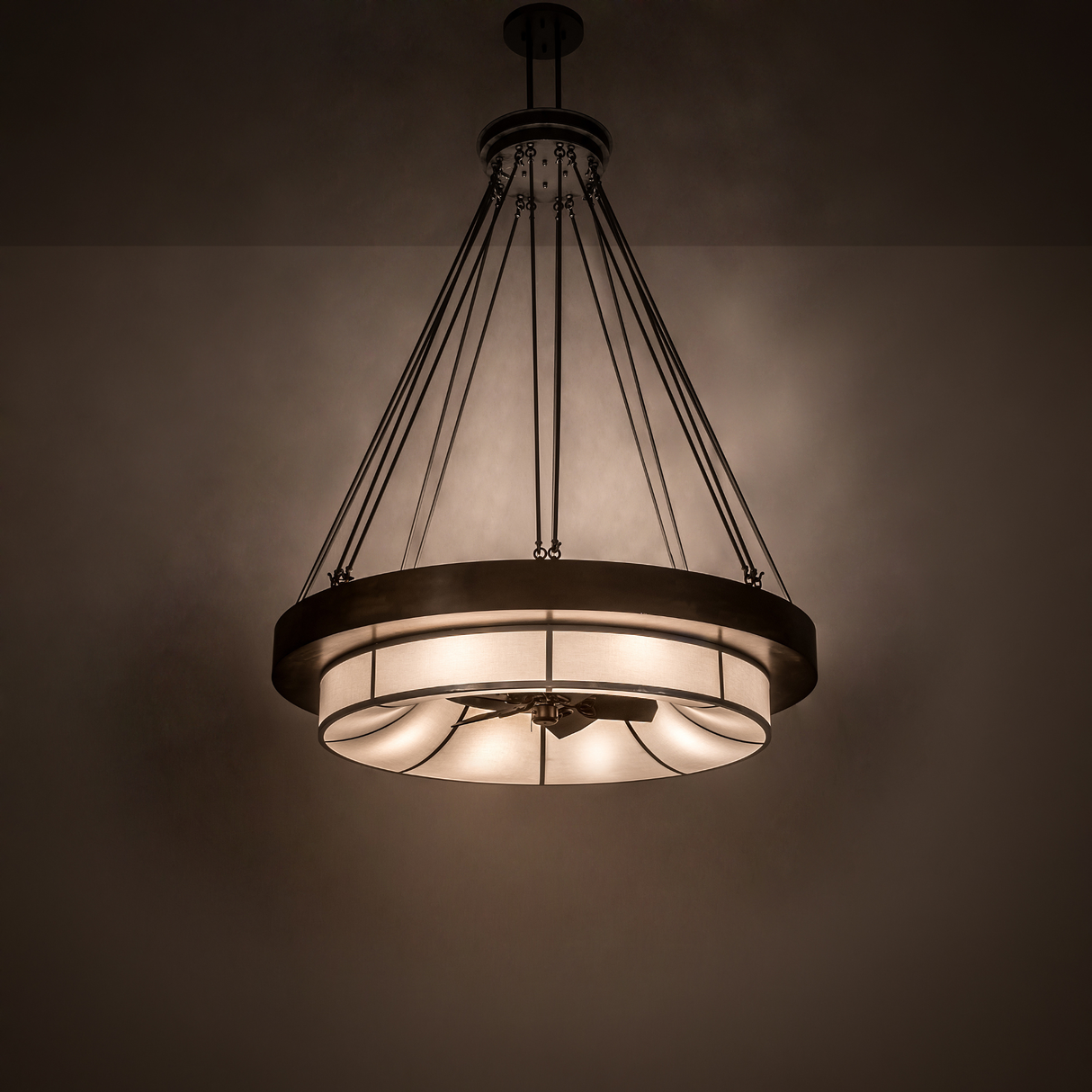 Illuminated Cilindro Ventura Chandel-Air casting warm light in a dark room setting.