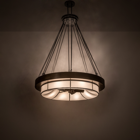 Illuminated Cilindro Ventura Chandel-Air casting warm light in a dark room setting.