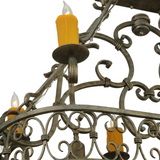 Close-up focus on scroll patterns and warm candlelight of Cira chandelier.