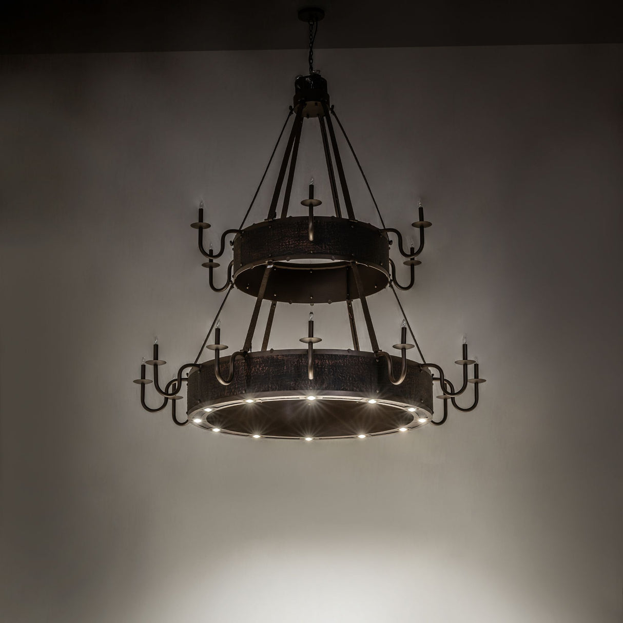 Dark room view of the Costello chandelier illuminated by down lights.