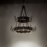 Dark room view of the Costello chandelier illuminated by down lights.
