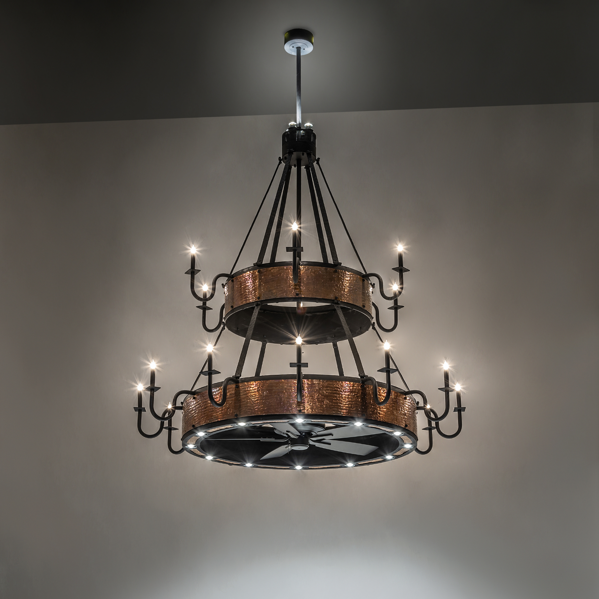Illuminated Costello chandelier fan glowing in warm ambient light.