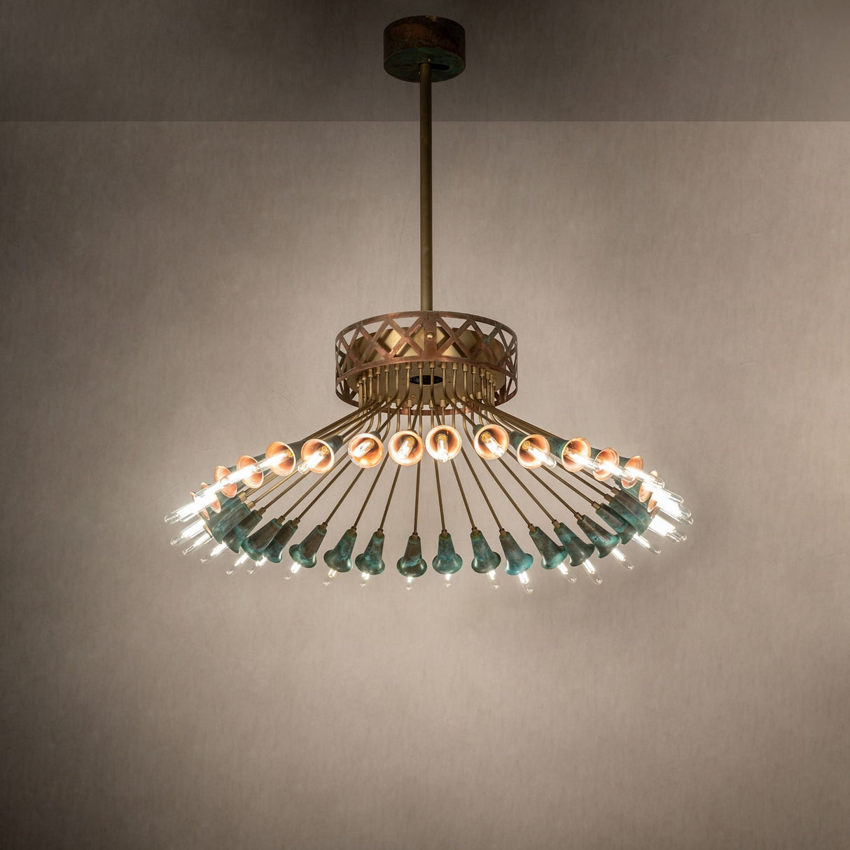 Coyle 36 light chandelier installed in interior setting with warm lighting and verdigris copper details.