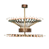 Side view of chandelier featuring brass tubing and verdigris copper trumpet lily socket cups.