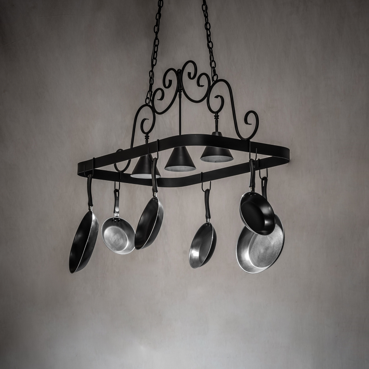 Black iron Elana 3 light pot rack lit in kitchen setting.