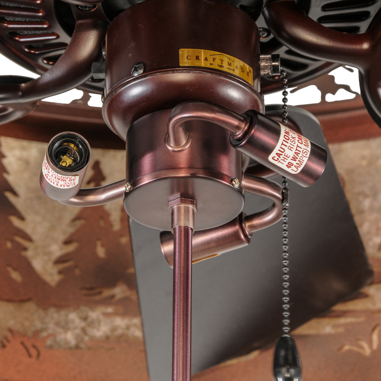 Closeup of fan motor assembly with chain pull and socket detail.