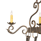 Close-up of Eloise chandelier arm with scrollwork and candlelight.