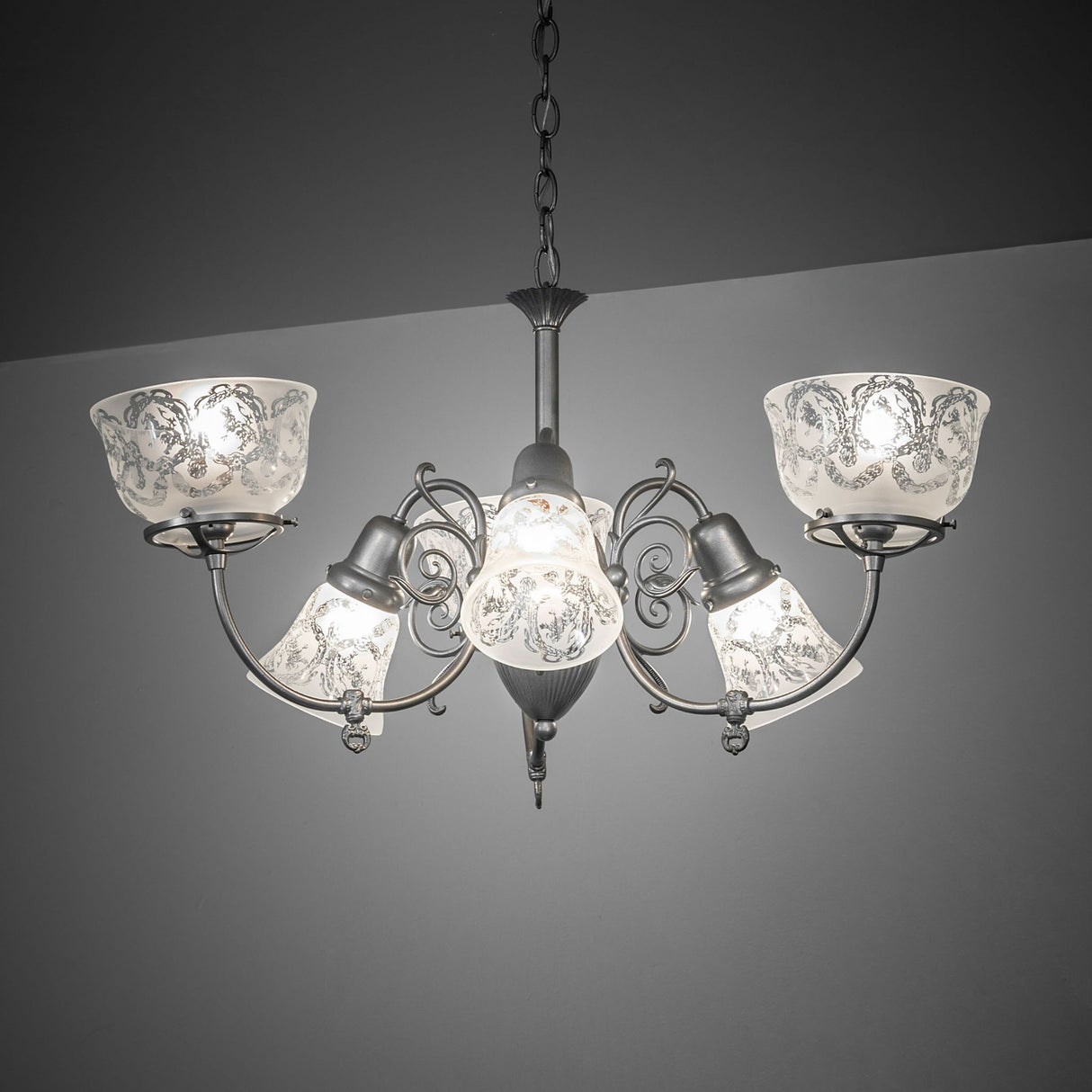 Gas and electric 6 light chandelier illuminated in an ambient interior setting.