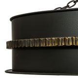 Close-up of hammered iron band with antique brass edge highlights.