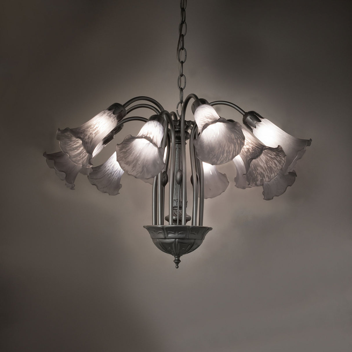 Gray pond lily chandelier glowing in ambient room setting.