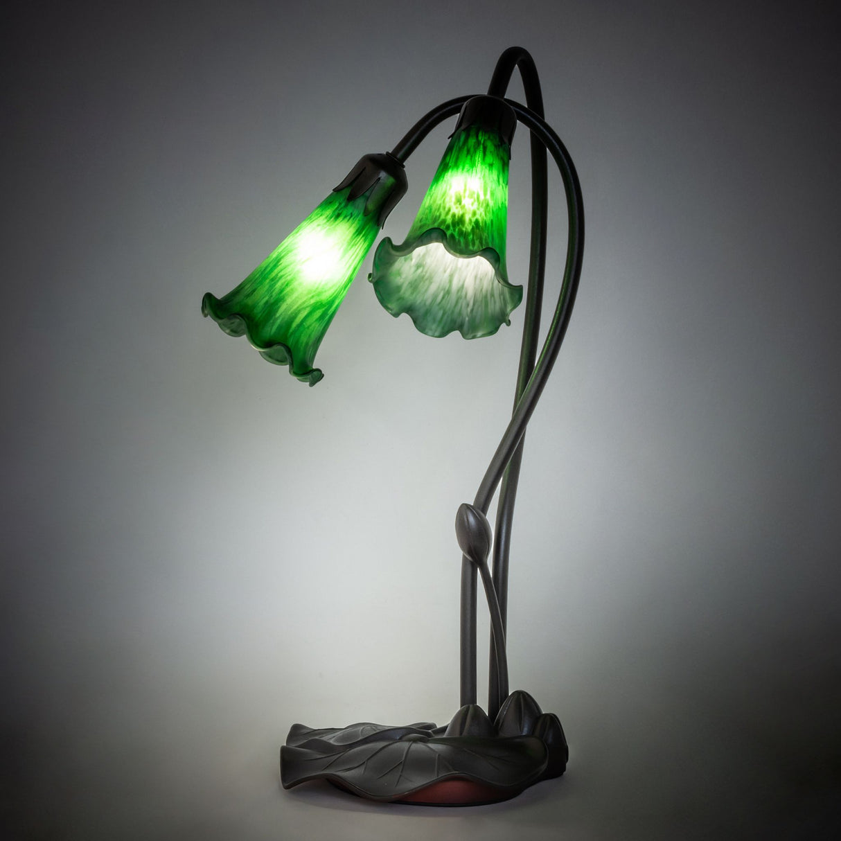 Illuminated view of the Green Tiffany Pond Lily accent lamp glowing with rich emerald hues.