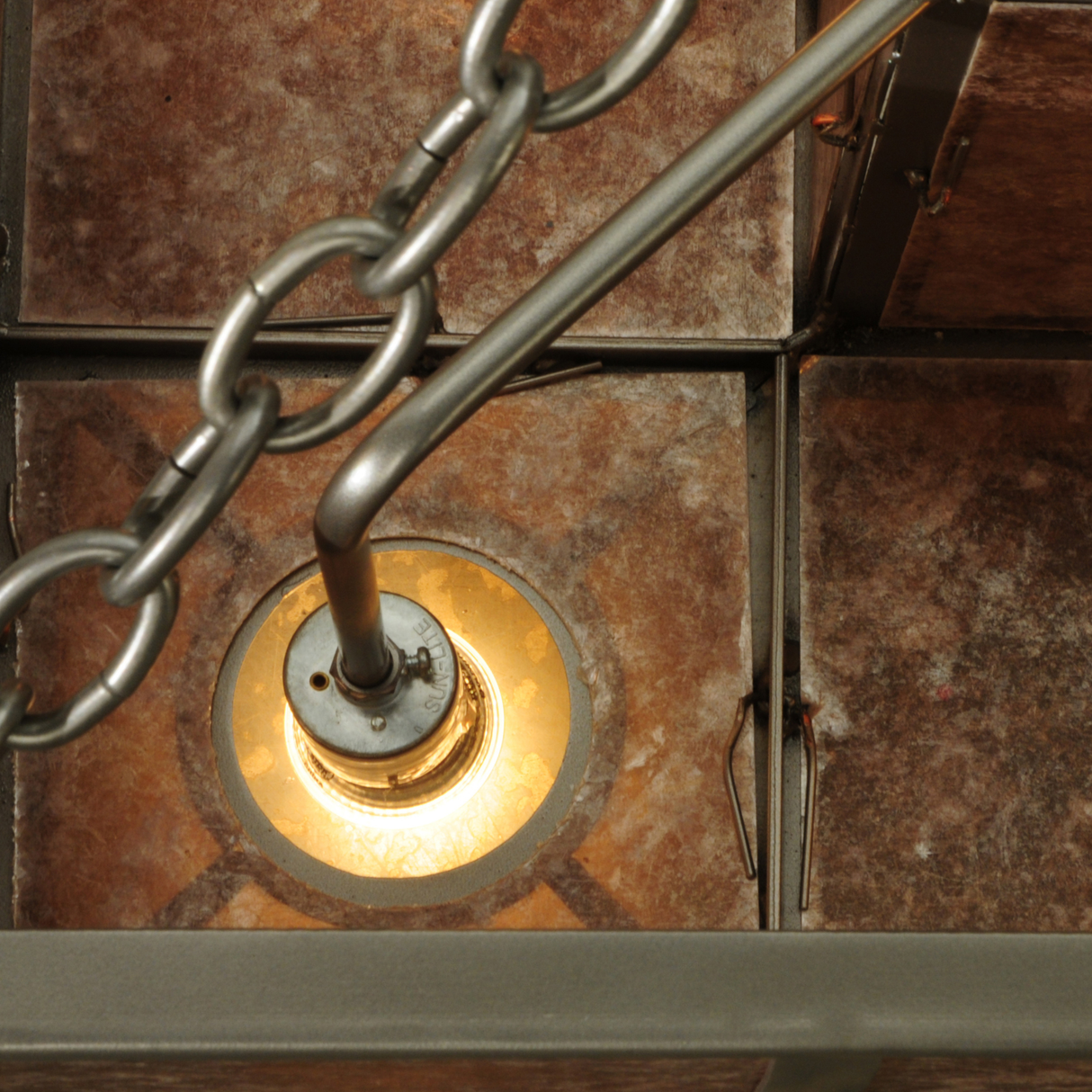 Close-up of illuminated socket and silver mica panel with chain detail.