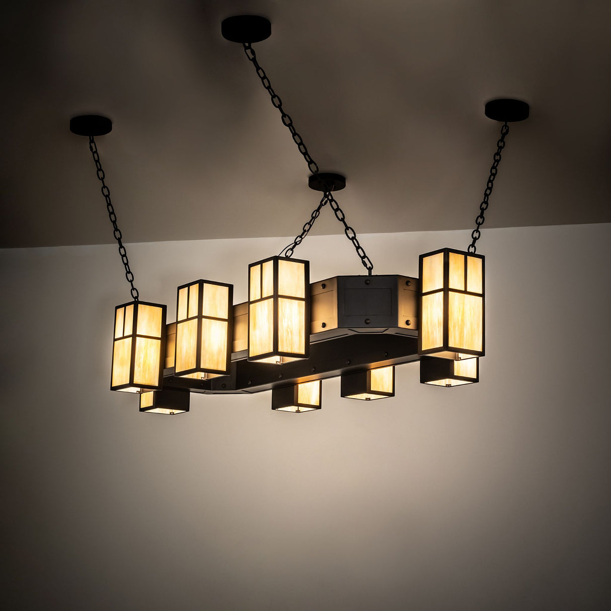 Chandelier illuminated with warm ambient glow in mission-style lantern design.