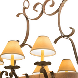 Closeup of Laramie chandelier lampshades glowing warmly.