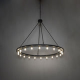 Ambient view of the chandelier casting a warm glow from its circular solar black frame.