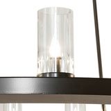 Close-up detail of a clear glass cylinder shade with candle-style bulb on the chandelier.