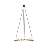 Lit view of the chandelier with clear glass cylinder shades and bronze finish.