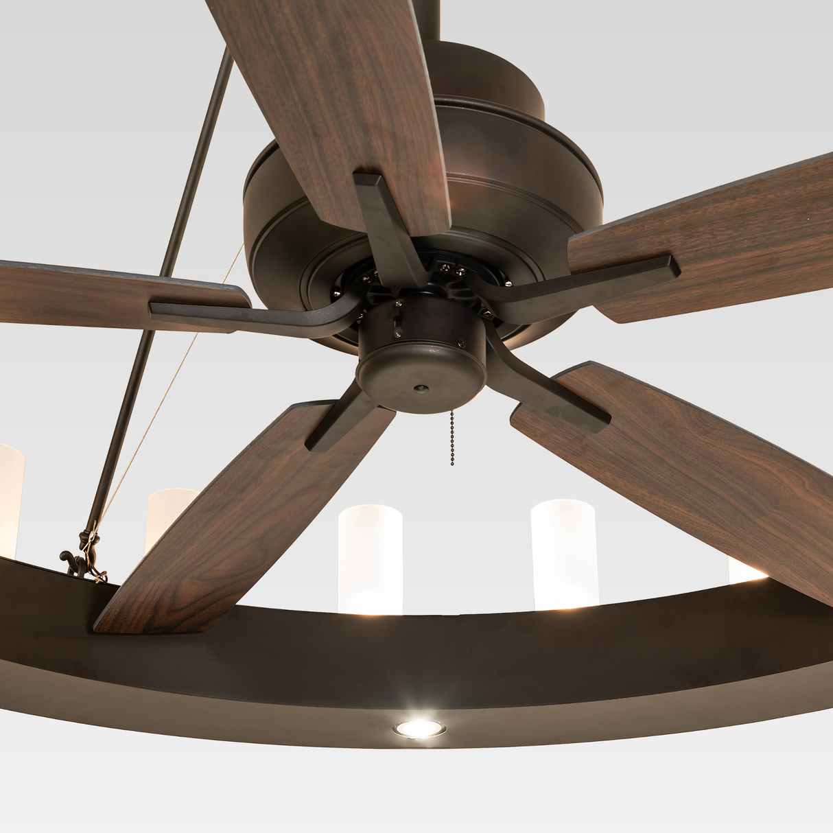 Close-up of Loxley chandelier fan showing wooden fan blades and metal motor housing.