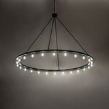 Loxley 24-light chandelier illuminated, casting warm ambient light from Edison bulbs.