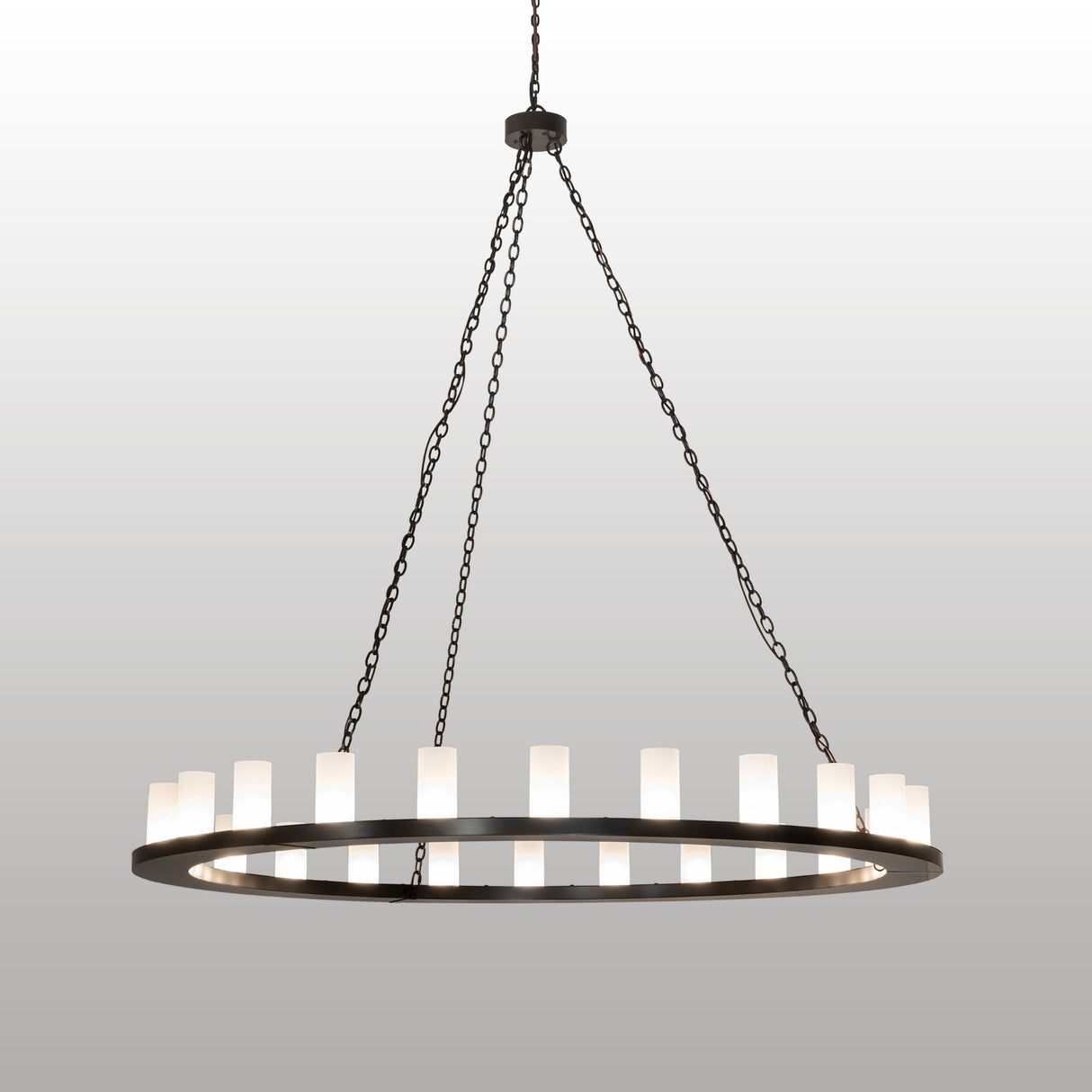 Lit view of 24 light chandelier with glowing frosted clear glass cylinder shades.