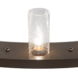 Close-up of seeded glass cylinder shade on chandelier with glowing bulb detail.