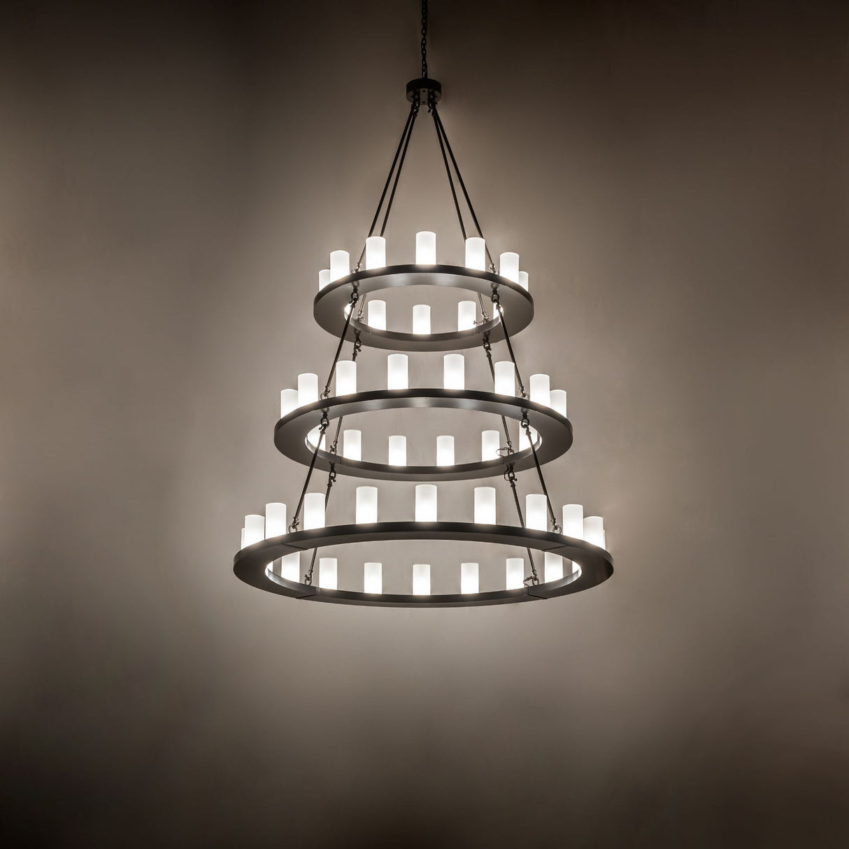 Ambient view of chandelier showing warm glow in a dim interior setting.