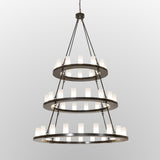 Lit view of the chandelier featuring illuminated glass lights on bronze rings.