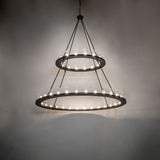 Ambient view of two tier chandelier illuminated in dark room setting.